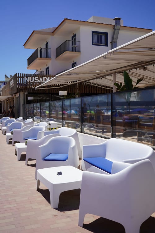 Hotel Sa Roqueta beachfront terrace with white modern chairs, retractable awning, and Mediterranean views in Can Picafort