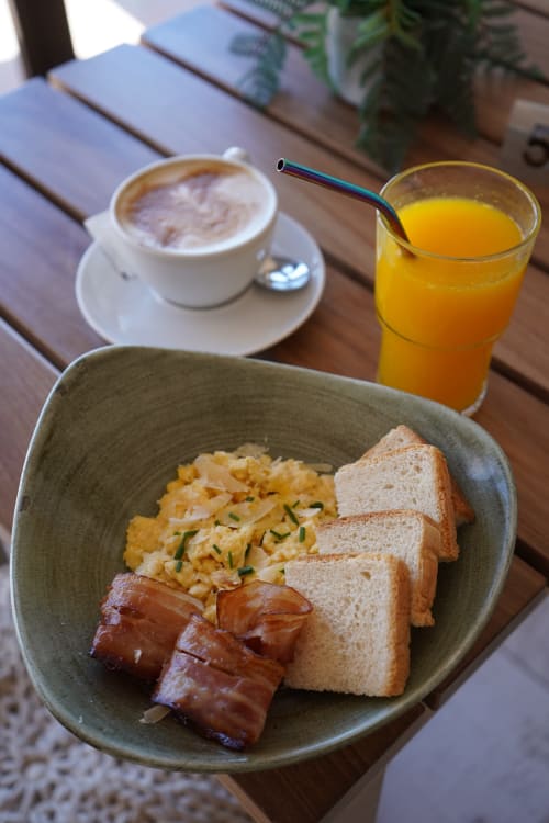 Colazione all'Hotel Sa Roqueta: uova strapazzate, toast, pancetta con succo d'arancia e cappuccino a Can Picafort