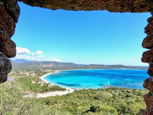 Vista sulla baia turchese incorniciata da muri in pietra, Villas Lantana a Lecci, Corsica
