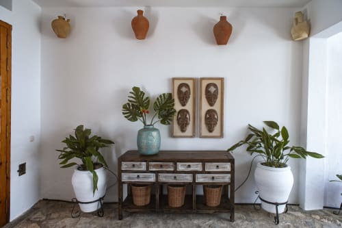 Styled interior at La Casa De La Abuela Regina with decorative pottery, plants, wooden furniture, and tribal art in Grazalema