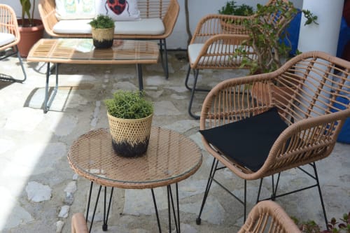 Woven rattan chairs and round table with potted plant at La Casa De La Abuela Regina outdoor patio in Grazalema