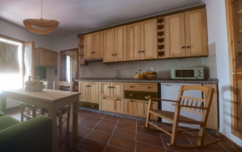 Amplia cocina del Apartamento Simancón en La Casa De La Abuela Regina, Grazalema, con muebles de madera y granito