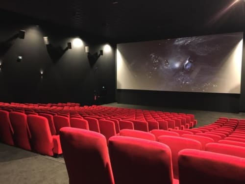 Moderna sala cinematografica con poltrone rosse e grande schermo presso l'hotel boutique Villas Lantana a Lecci, Francia