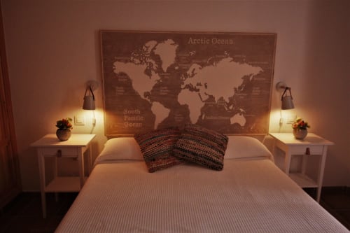 Acogedora habitación en La Casa De La Abuela Regina en Grazalema con mapamundi sobre la cama, lámparas de noche e iluminación ambiental
