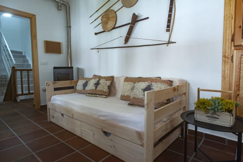 Wooden bed with white mattress and patterned pillows in Pinsapar apartment at La Casa De La Abuela Regina, Grazalema