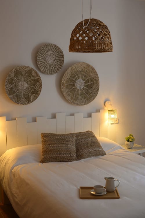 Acogedora habitación en La Casa De La Abuela Regina en Grazalema con arte textil en pared, lámpara colgante y servicio de té en la cama