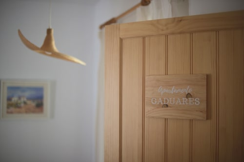 Entrada del apartamento Gaduares en La Casa De La Abuela Regina en Grazalema con letrero de madera y decoración minimalista moderna