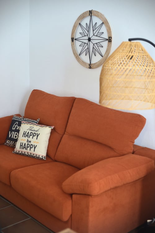 Cozy seating area in Zurraque Apartment at La Casa De La Abuela Regina with burnt orange sofa, decorative pillows, woven