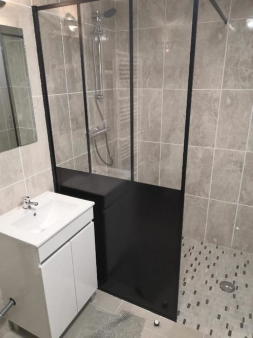 Salle de bain contemporaine avec douche à l'italienne, meuble vasque blanc et carrelage gris à l'appartement Sci Saviya à Égletons
