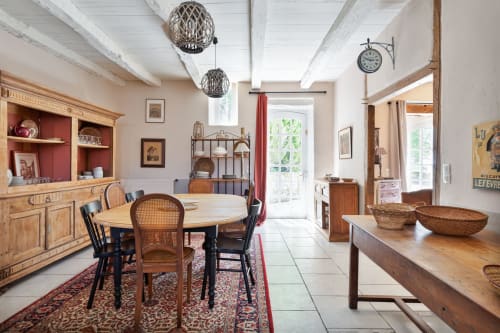 Spacious cottage dining area at Les Lumieres Du Causse with round table, wooden furniture, and French countryside decor