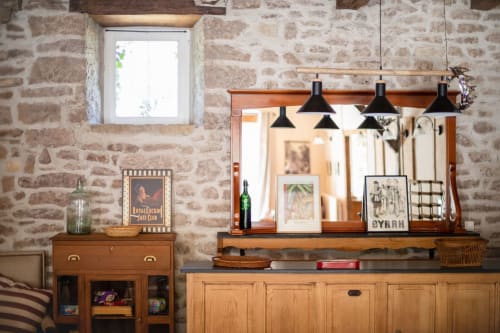 Rustic stone cottage interior with wooden furniture, pendant lights, and decorative shelving at Les Lumieres Du Causse