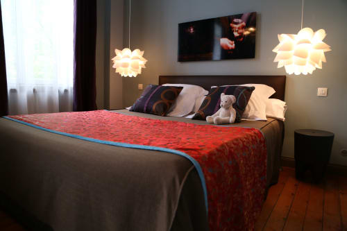 Modern bedroom at Le Grand Duc BnB in Valenciennes with red bedcover, pendant lights, and city view