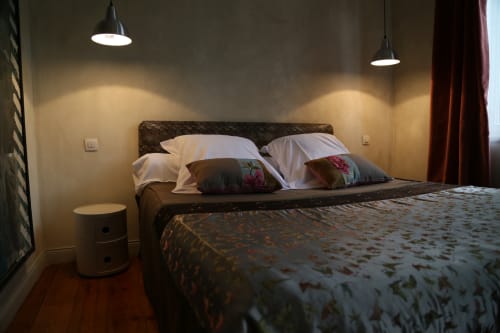 Modern bedroom at Le Grand Duc BnB in Valenciennes with dark wood bed, white pillows, pendant lights, and warm ambient