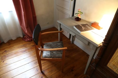 Bedroom workspace at Le Grand Duc B&B in Valenciennes with wooden desk, chair, and garden view curtains