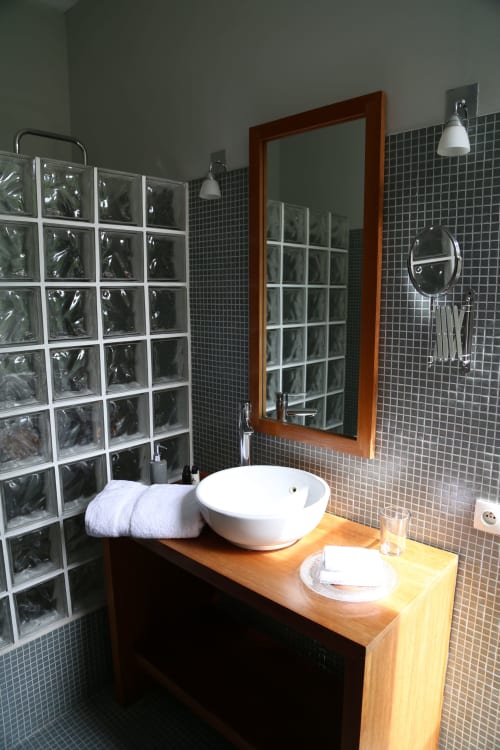 Salle de bain moderne du B&B Le Grand Duc à Valenciennes avec vasque, douche en briques de verre et meuble de salle de bain en bois