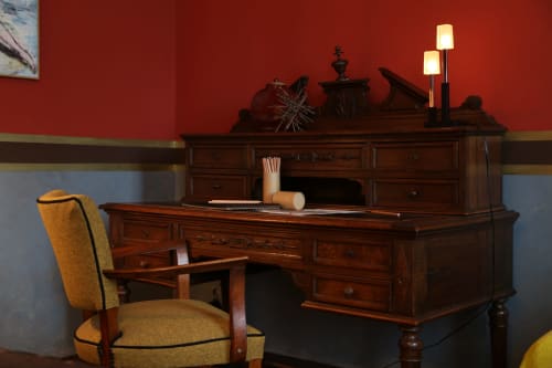 Élégant bureau et chaise en bois dans la chambre Le Grand Duc aux murs rouges, idéal pour travailler ou écrire