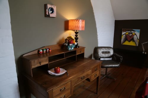 Wooden desk with orange lamp and decorative items in Chapter 5 room at Le Grand Duc B&B, Valenciennes