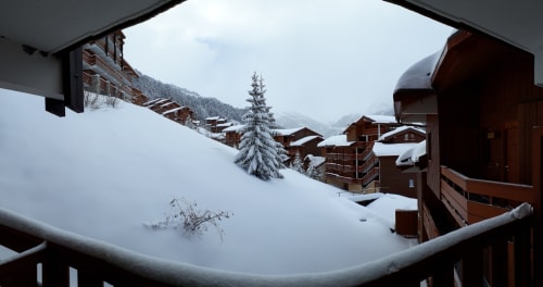 Vue enneigée des chalets CMD Méribel Le Pralin aux Allues, Alpes françaises, avec bâtiments couverts de neige nichés dans la montagne