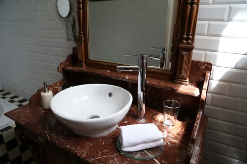 Élégante salle de bains au Le Grand Duc B&B à Valenciennes avec plan de travail en marbre, vasque blanche et miroir boisé