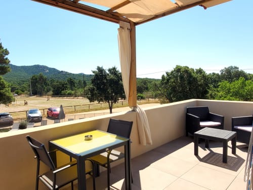 Sonnige Terrasse der Villas Lantana in Lecci mit Esstisch, Loungbereich und Bergblick