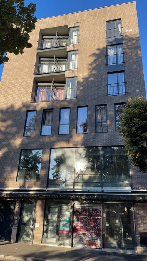 Façade extérieure de l'hôtel Chambre Pasteur à Montreuil avec briques, balcons et entrée du restaurant au rez-de-chaussée