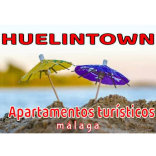 Apartamentos turísticos Huelintown en Málaga con sombrillas de playa coloridas en la arena junto a la orilla