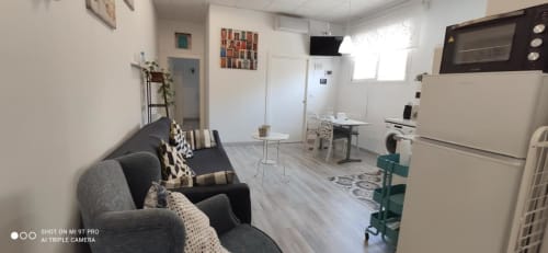 Moderno apartaestudio en Apartamentos Huelintown, Málaga, con sala de estar, cocina y mobiliario contemporáneo