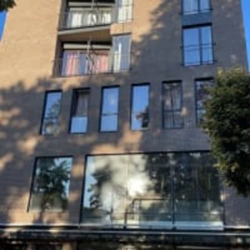 Façade contemporaine de l'hôtel Chambre Pasteur à Montreuil avec grandes fenêtres et balcons à cadre bleu