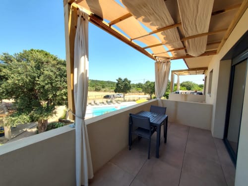 Shaded terrace at Villas Lantana with dining table overlooking pool and Corsican landscape, Lecci