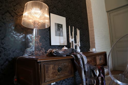 Chambre élégante du B&B Le Grand Duc à Valenciennes avec lampadaire moderne, papier peint à motifs sombres, tableaux encadrés et boiseries