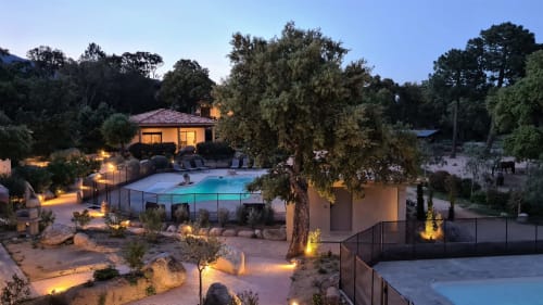 Twilight-Blick auf die Villas Lantana: beleuchteter Pool, Terrasse und Außenlounge-Bereich umgeben von mediterranen Bäumen in Lecci