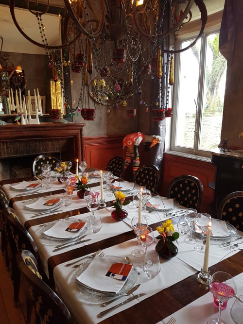 Salle à manger élégante du gîte Le Grand Duc à Valenciennes avec dressage formel, lustres suspendus et décor raffiné