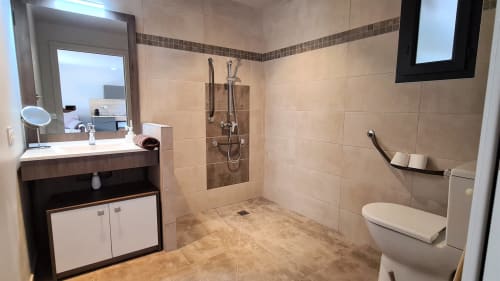 Modernes Badezimmer in der Villas Lantana mit begehbarer Dusche, Waschtisch, Toilette und Fliesendesign in Erdtönen in Lecci, Korsika.