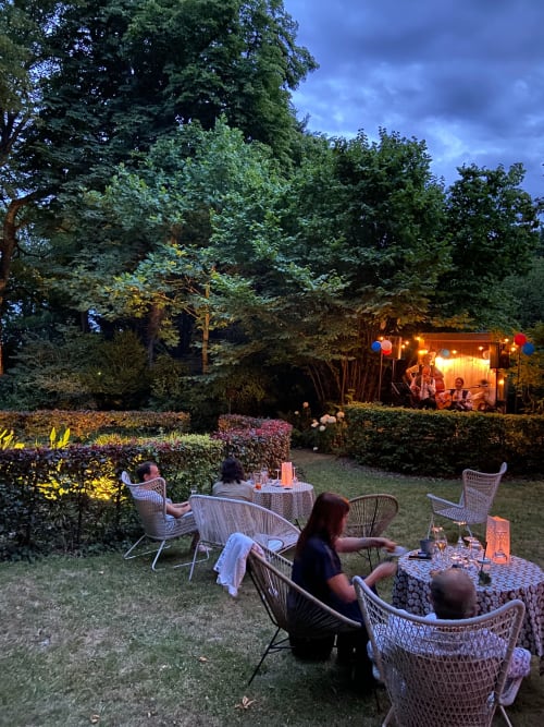 Soirée en jardins du Gîte Le Grand Duc à Valenciennes, clients en détente sous lumières festives