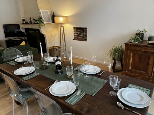Elegantly set dining table at Le Prieuré Du Preux in Sépeaux, France with white plates, wine, and table settings