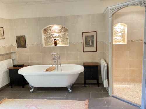 Luxurious spa bathroom with freestanding bathtub, tiled walls, and walk-in shower at Les Lumieres Du Causse cottage,
