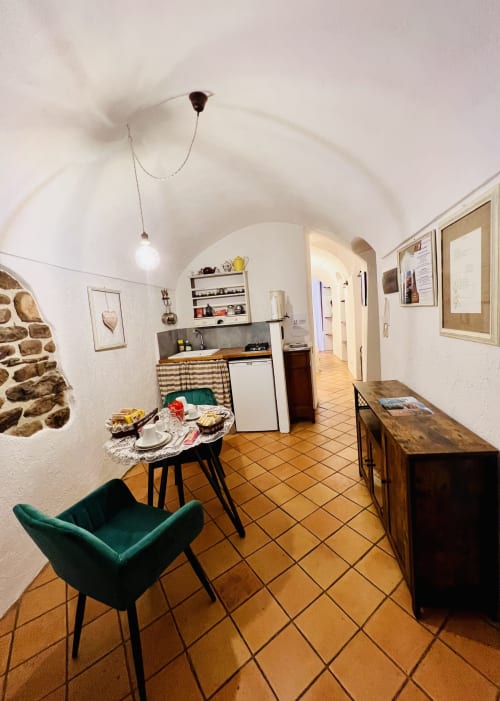 Kitchenette moderne à Dolceacqua avec coin repas, électroménagers blancs et chaise en velours vert