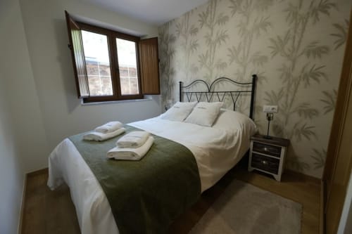Acogedora habitación en el apartamento rural Balbino de León con cama doble, vistas a la montaña y decoración tradicional