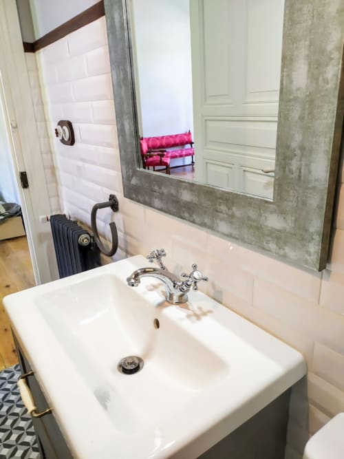 Moderno lavabo de baño con grifo cromado y espejo grande en la Suite Pintueles del hotel La Venta de Miyares