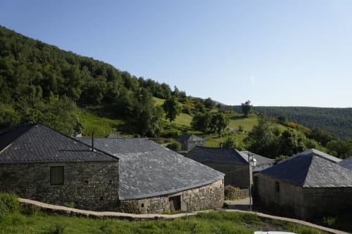 Casas rurales de piedra con tejados de pizarra en las verdes colinas de Balbino, alojamiento turístico en Prado Novo, León