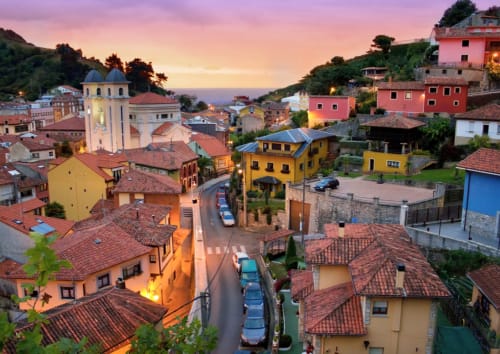 Coloridas casas coloniales en el pueblo de Miyares al atardecer, hotel La Venta de Miyares en el paisaje montañoso de Asturias
