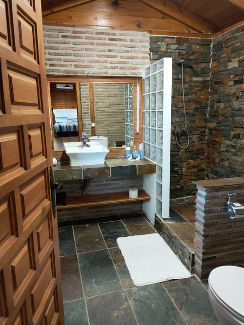 Baño de Gencianilla en El Paraje del Chef con pizarra, tocador de madera, ducha de piedra y vistas a la montaña