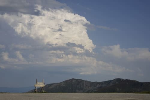 Dramáticas nubes blancas de cúmulo sobre paisaje disperso con estructura de madera y colinas oscuras cerca de Prado Novo, León