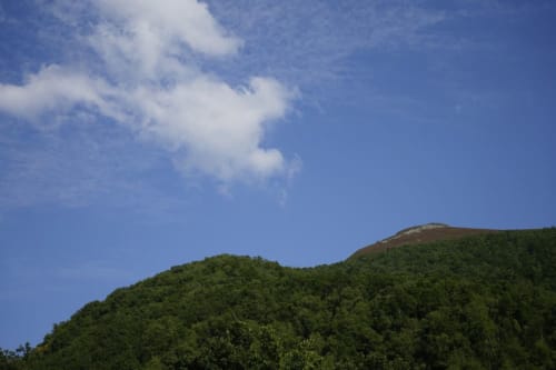 Colinas boscosas verdes bajo cielo azul con nubes cerca de la vivienda turística Balbino, Prado Novo, León