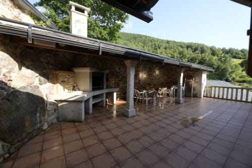 Terraza de piedra con zona de comedor con vistas a montañas boscosas en la propiedad rural Balbino en León, España