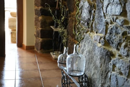 Corredor de piedra con maceteros colgantes de cristal y arquitectura cubierta de líquenes en la propiedad rural Balbino de León