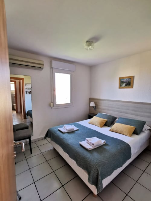 Chambre lumineuse à la Résidence Saint Michel à L'île Rousse avec lit queen-size, climatisation et accès balcon