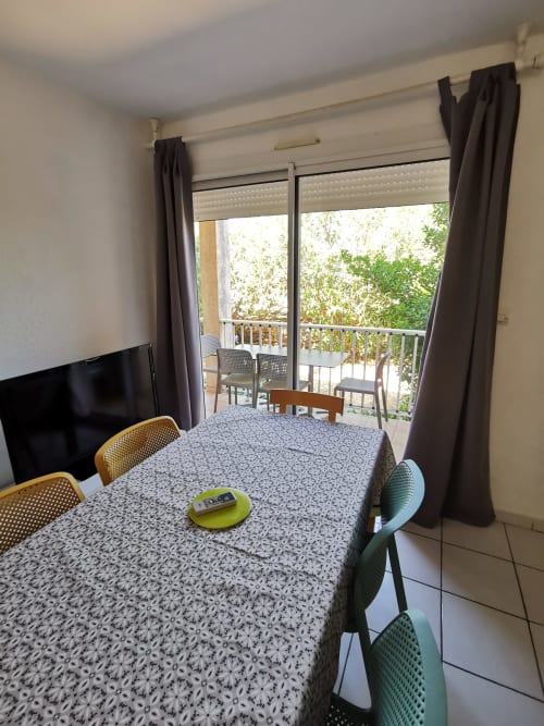 Coin repas de l'appartement avec vue sur balcon à la Résidence Saint Michel, L'île Rousse, table, chaises et mobilier moderne