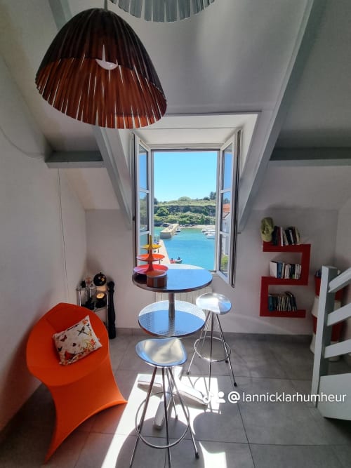 Appartement côtier moderne avec accents rouges, bar et vue spectaculaire sur le port de Belle-Île-en-Mer par portes ouvertes