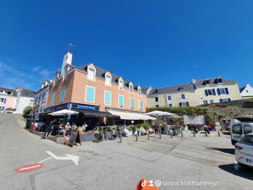Charmante place côtière à Locmaria, Belle île en mer, avec ses bâtiments colorés et sa terrasse de café